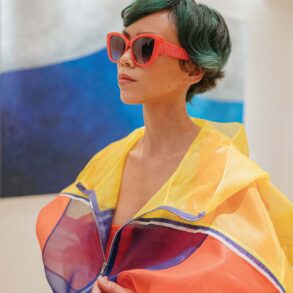 Windbreaker, knitted dress, and T Timeless bag from TOD’s. Red 54mm cat-eye sunglasses by Alexander McQueen.