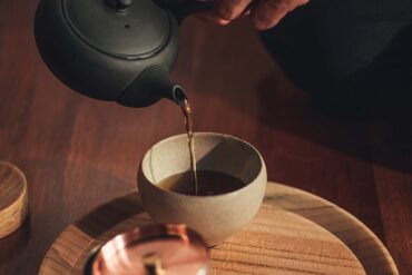 a person pouring liquid into a cup