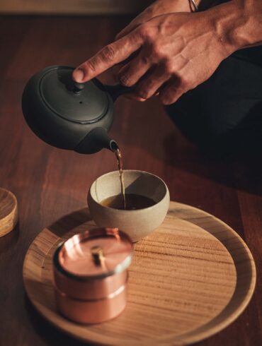 a person pouring liquid into a cup