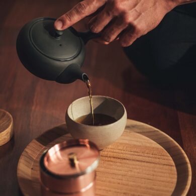 a person pouring liquid into a cup