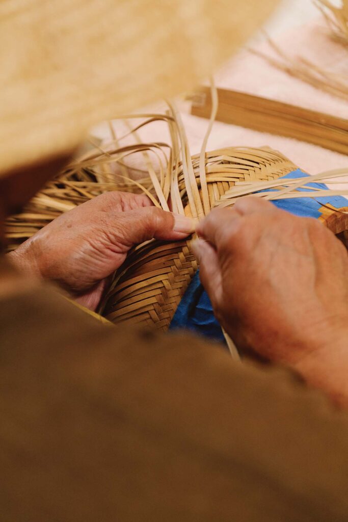 a person weaving a basket
