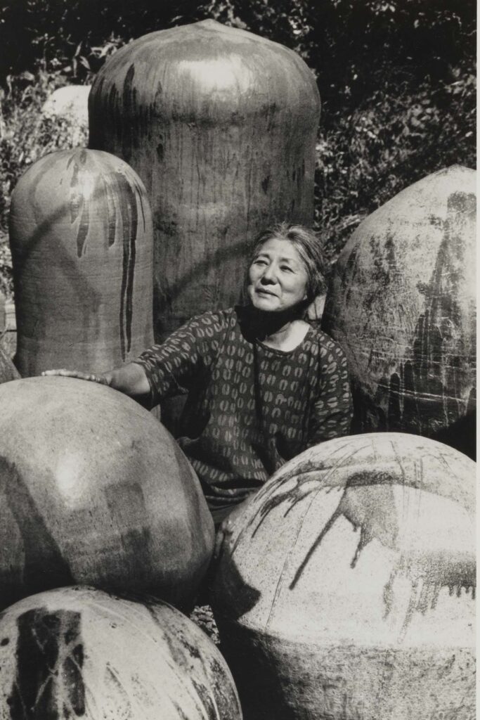 a person sitting next to large round objects